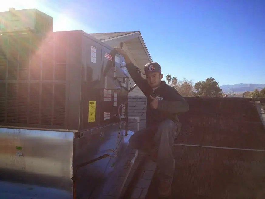 HVAC technician performing Boiler Repair on a rooftop unit in Costa Mesa